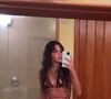 Bruna Marquezine posou no espelho durante uma viagem exibindo a barriga trincada em um biquíni super diferente, em tons terrosos com amarração na cintura.